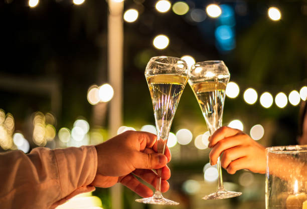 copas de champán y manos humanas, manos sosteniendo copas de champán en luces de fondo - fiesta en la oficina fotografías e imágenes de stock