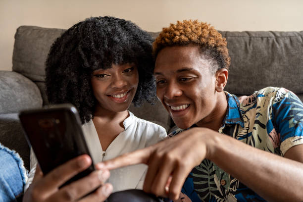 istock A couple uses a smartphone device, sitting in a living room 1484149105