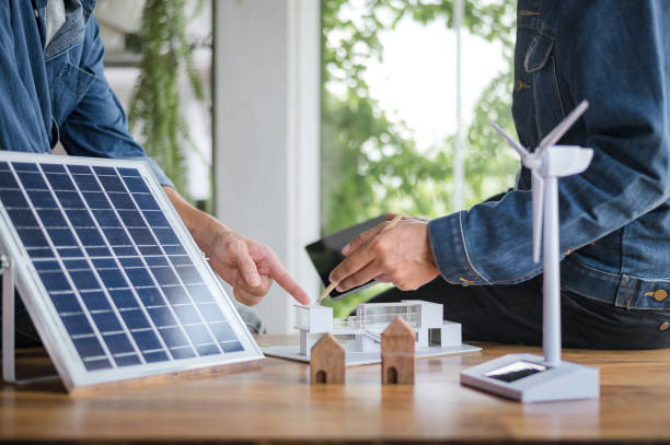 istock Close-up at model house, Engineers pointing at model house with their hands. To jointly design the use of renewable energy with wind and solar energy. Concept of using renewable energy. 1484149201