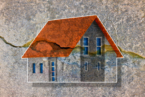 Deep crack in old brick wall with damaged plaster and colored house model - concept image