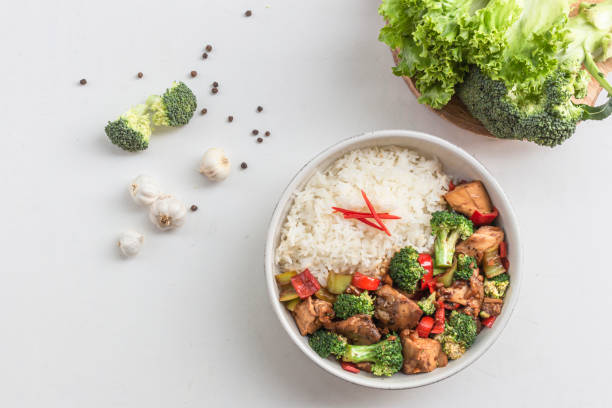 istock Stir fried chicken and broccoli bell pepper has rice in bowl on white wood table. 1484150610
