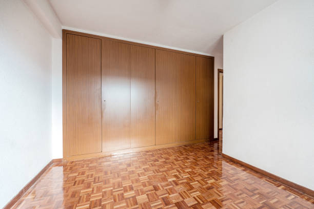 istock Empty room with recently varnished parquet floor and wall covered by a built-in wardrobe 1484150639