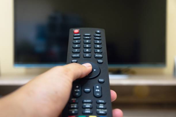 istock hand holding tv remote 1484155897
