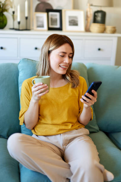 istock Woman using smartphone while drinking coffee at her home in the morning 1484156409