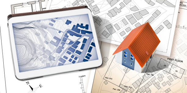 istock Cadastral map with buildings, free land parcel for house construction - building activity and construction industry concept with home model and digital tablet 1484156613