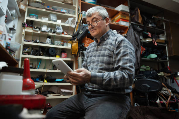 Shoemaker using digital tablet stock photo