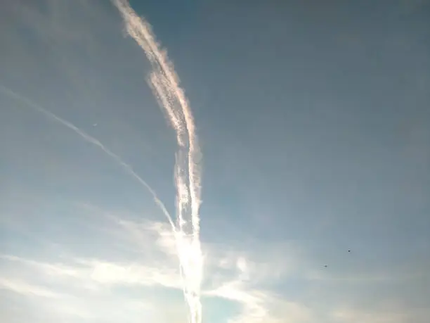 Dramatic jet contrail with blue sky for background and texture.