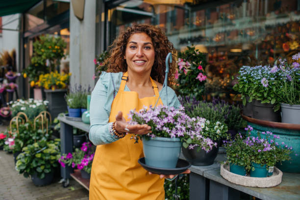 Beautiful diverse female florist working in her flower shop stock photo