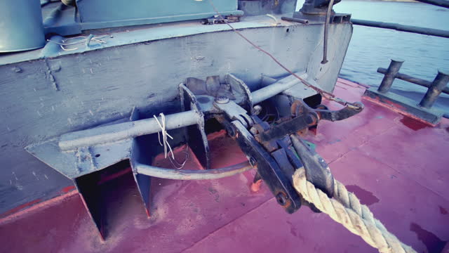 Rope fastening on a boat. clip. Dark red floor background on a boat. Metal boat with hook for transportation
