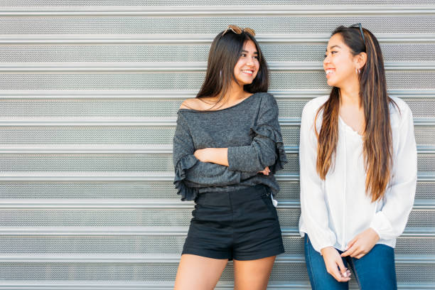 istock Cheerful women standing near wall and looking at camera 1484167531
