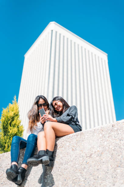 istock Cheerful women sitting on stone 1484167546