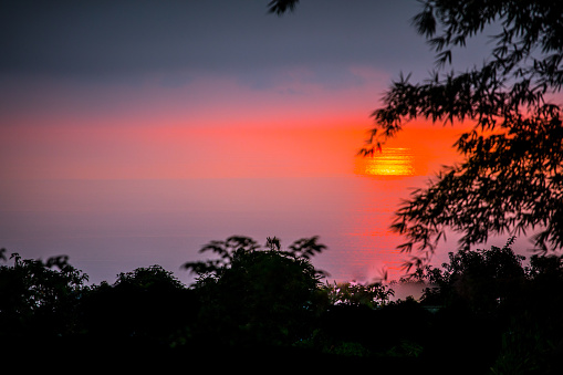 Beautiful Classic Tropical Sunset with Trees in Foreground Sun Setting Hawaii Ocean