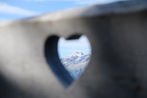 Piz Boe in Dolomites, Italy, through heart carved out in a bench
