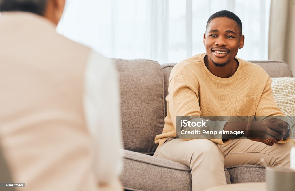 Black man, counseling and psychology consulting for therapy, mental healthcare or support. Happy patient talking to psychologist, therapist and medical help in consultation, advice and wellness check Mental Health Professional Stock Photo