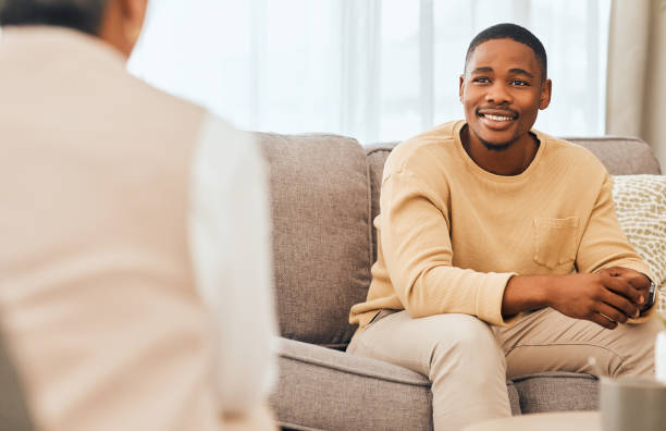 homem negro, aconselhamento e consultoria psicológica para terapia, saúde mental ou apoio. paciente feliz conversando com psicólogo, terapeuta e ajuda médica em consulta, aconselhamento e verificação de bem-estar - councilling - fotografias e filmes do acervo