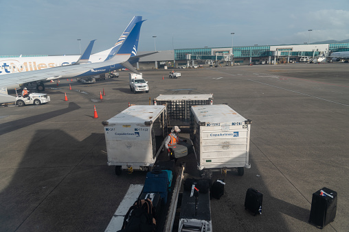 Worker loading suitcases at the Tocumen airport. City of Panama. Panama. July 25, 2022.