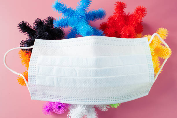 istock mask and coronavirus. multicolored coronavirus from the children's designer with Velcro on a pink background. Respiratory infection protection concept 1484183472