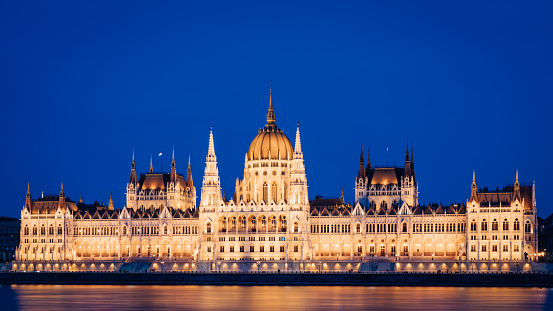 Budapest Hungary Blue Hour Twilight Panorama of the Hungarian Parliament Building. After Sunset Twilight Panorama towards the Parliament Building also known as the Parliament of Budapest on the Riverside of the Danube River. Hungarian Parliament Building on the Pest City Side of Budapest. Budapest, Hungary, Eastern Europe