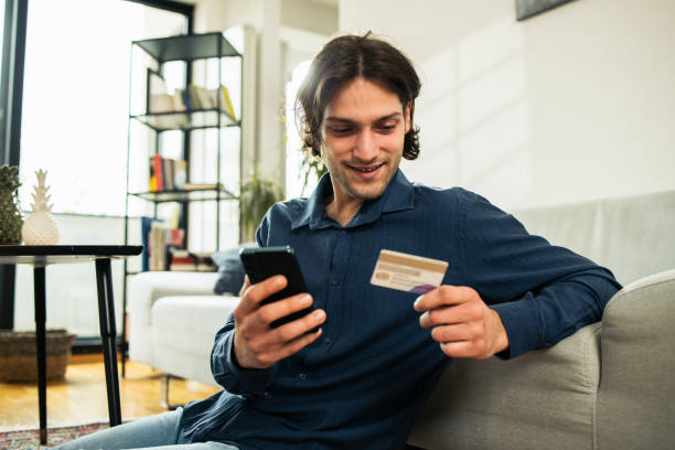 istock Young man shopping online at home 1484184954