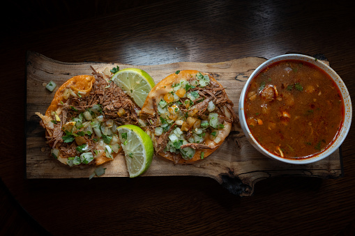 Los deliciosos tacos callejeros con birria o carne asada, servidos en una tortilla de maíz caliente con cebolla, cilantro y salsa, son un plato mexicano popular y sabroso. photo