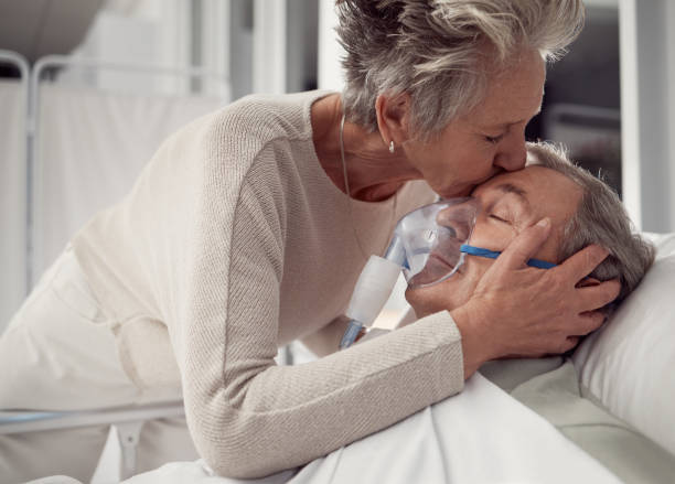 hospital, beijo e casal idoso com amor, união e esperança de recuperação na clínica. apoio, cuidado e mulher idosa beijando homem ou paciente com diagnóstico de câncer, doente ou doente para conforto ou empatia - medical oxygen equipment healthcare and medicine 70s mature adult - fotografias e filmes do acervo