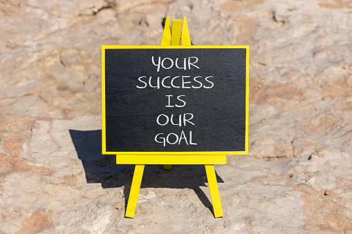 Your success is our goal symbol. Concept words Your success is our goal on black chalk blackboard on beautiful stone background. Success business goal concept. Copy space.