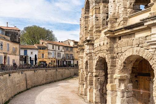 April 22, 2023: This photo captures the timeless beauty of Arles, a charming village located in the heart of Provence, France. The image shows a street lined with historic buildings, colorful shutters, and balconies. This photograph is perfect for travel and lifestyle publications seeking to showcase the unique beauty and cultural heritage of France. It can also be used as a decorative piece, evoking the romance and charm of French village life.