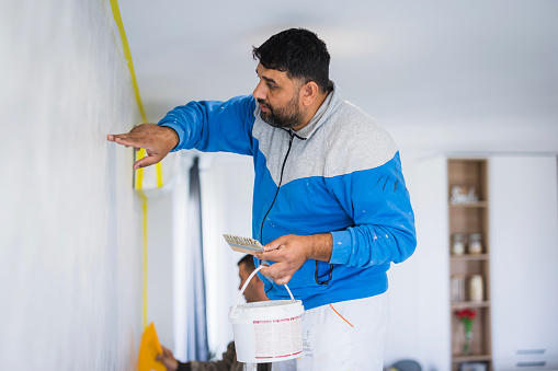 Man concentrating onto his job when painting the apartment walls