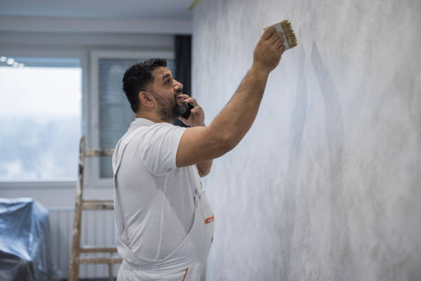istock Man painting the apartment wall and having a phone conversation 1484201606