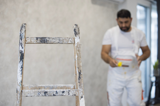 Ladder placed in front of a wall being painted and decorated