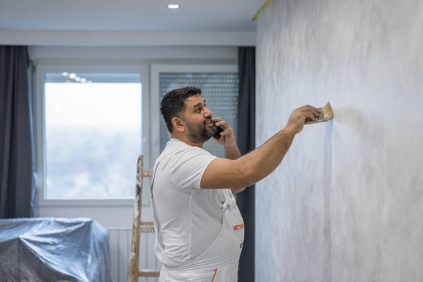 istock Man painting the apartment wall and having a phone conversation 1484202218