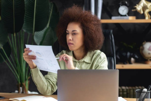 istock Focused business woman sitting at the workplace in the office analyzes documents 1484203240