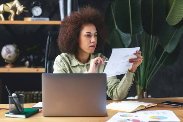 istock Focused business woman sitting at the workplace in the office analyzes documents 1484203277