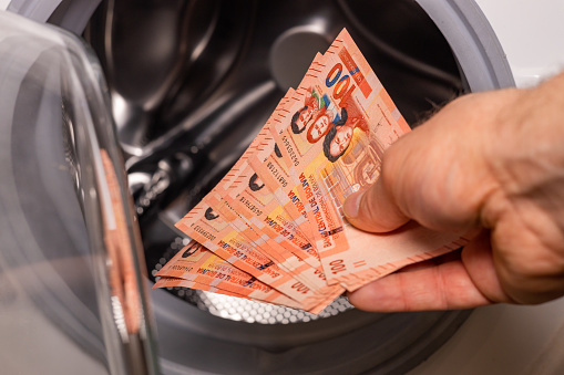 Bolivia money put into washing machine, Concept, Money laundering, illegal activity, black market, Criminal activity
