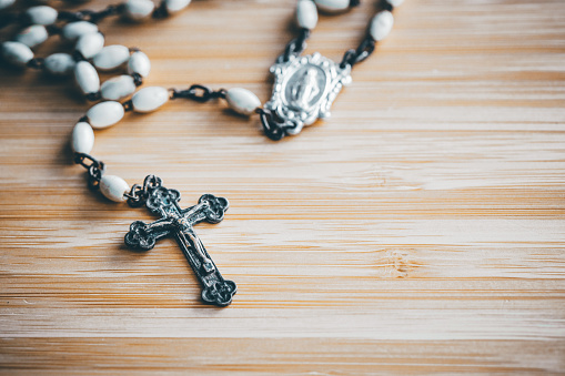 Rosary lying on the table, Catholic cross