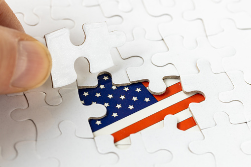 American flag among white puzzle pieces, US concept Politics and world economy