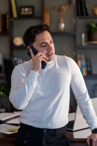 istock handsome young man in office talking by phone 1484212659