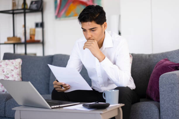 istock Young entrepreneur examines business bills 1484213659