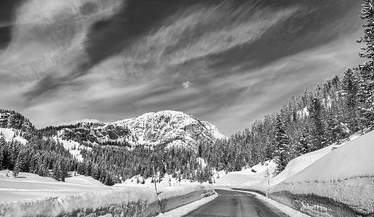 Road through a beautiful snowy valley, dolomite mountains in winter season.