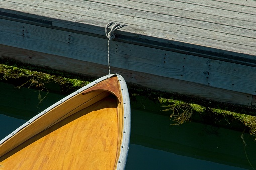 The bow or a skiff tied up to a dock in Boothbay Harbor Maine.