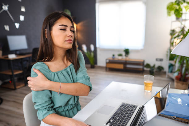 istock Young woman experiencing shoulder pain while working on laptop at home 1484218945