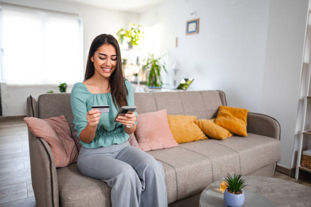 istock Lovely young woman online shopping while sitting on a sofa 1484219579