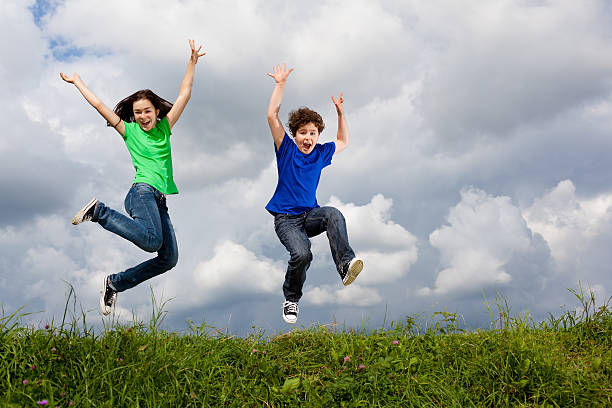 istock Girl and boy jumping outdoor 148422090