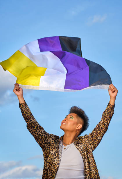 istock gender non binary asian person holding gender non-binary representative flag blowing in the wind 1484227894