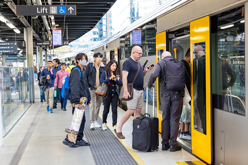 Sydney, Australia - April 22, 2023: Sydney Central train station, large group of people getting in and out of the train in rush hour