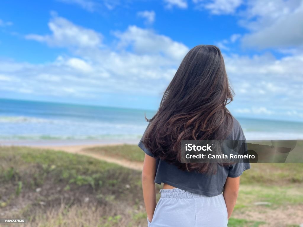 Long hair girl Long hair girl alone in front of the beach 12-13 Years Stock Photo
