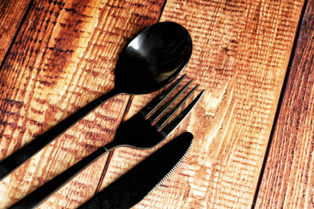 istock black steel cutlery on wooden table  background 1484238703