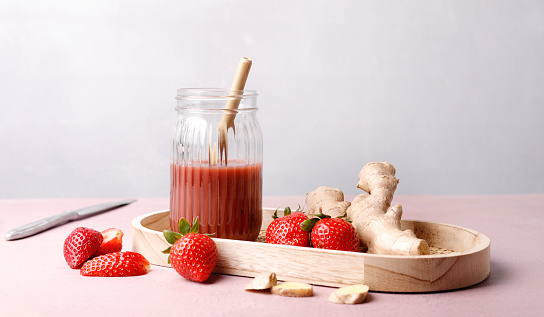 Making fresh organic strawberry smoothie with ginger