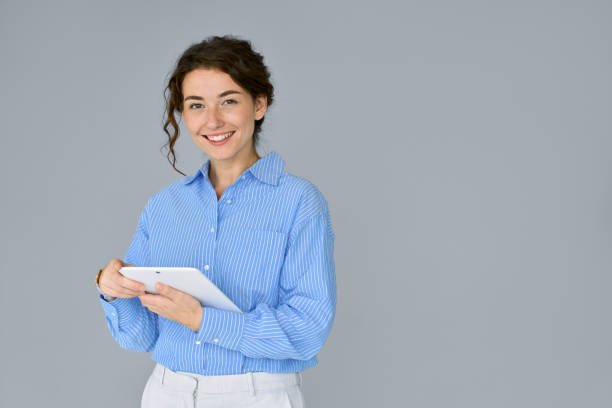 istock Young happy professional business woman using digital tablet isolated at grey. 1484245588