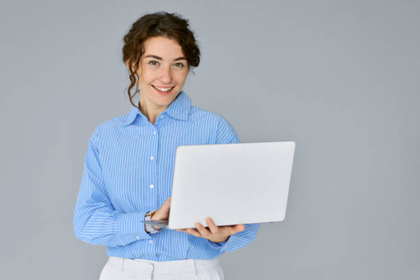 istock Young smiling business woman manager using laptop isolated on gray. 1484245604